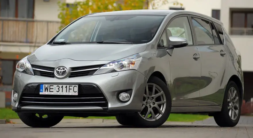 Srebrna Toyota Verso 1.8 benzyna zaparkowana przed domem.