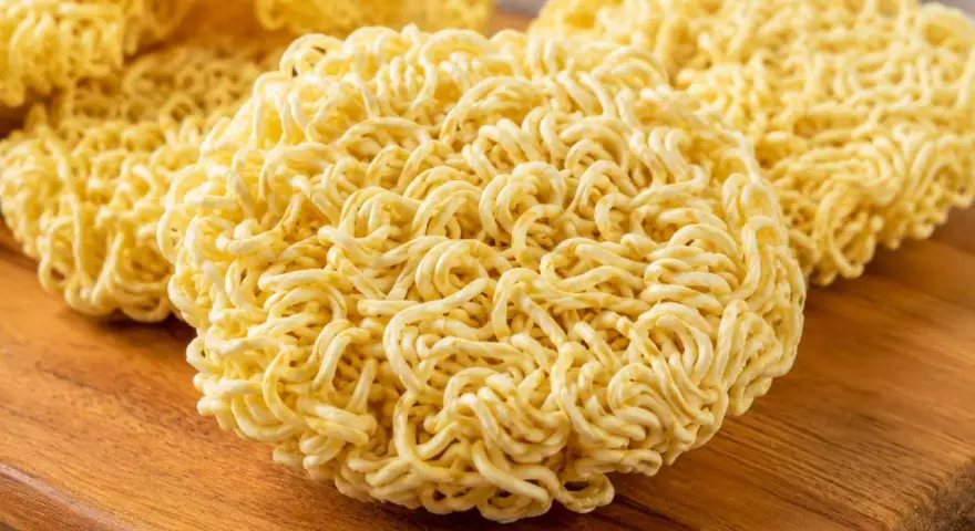 Suszone kluski do ramen na drewnianej desce. Idealne do szybkiego przygotowania pysznego dania.