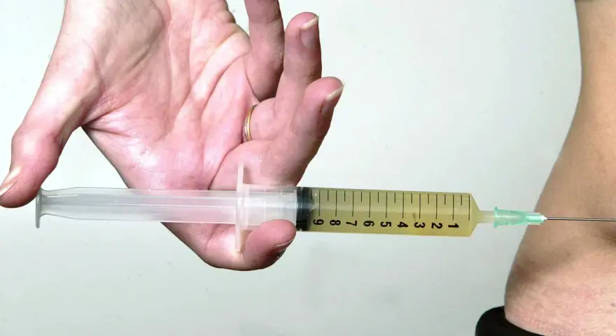 Spritze statt thrombose tabletten: Eine Spritze wird in den Bauch eingeführt, um eine Thrombose zu behandeln, besonders wichtig auf einem langen Flug.