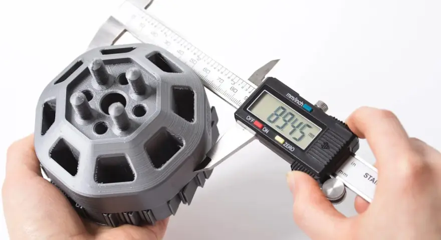 A caliper measures a 3D printed part, showcasing the precision of 3D printing.