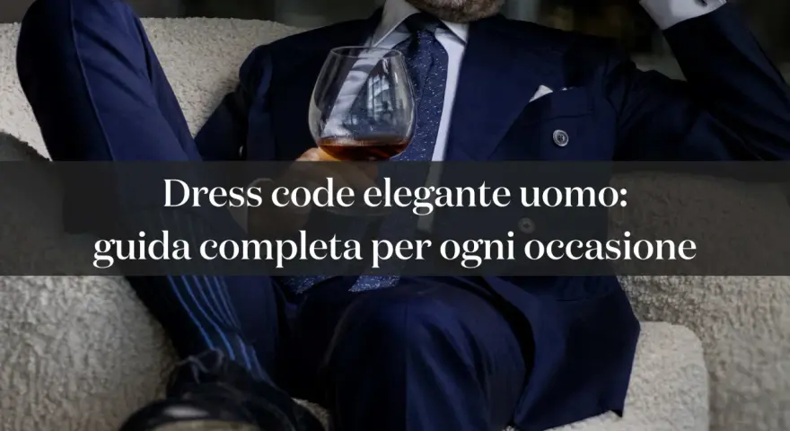Uomo in abito blu con bicchiere, esplora le diverse dress code tipologie per ogni occasione.