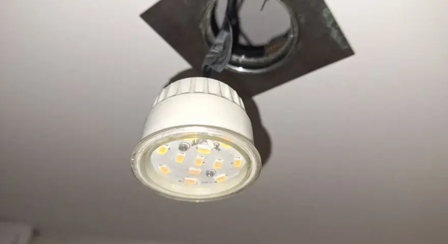 Wymiana żarówki led w oprawie sufitowej. Nowa, energooszczędna żarówka czeka na montaż.