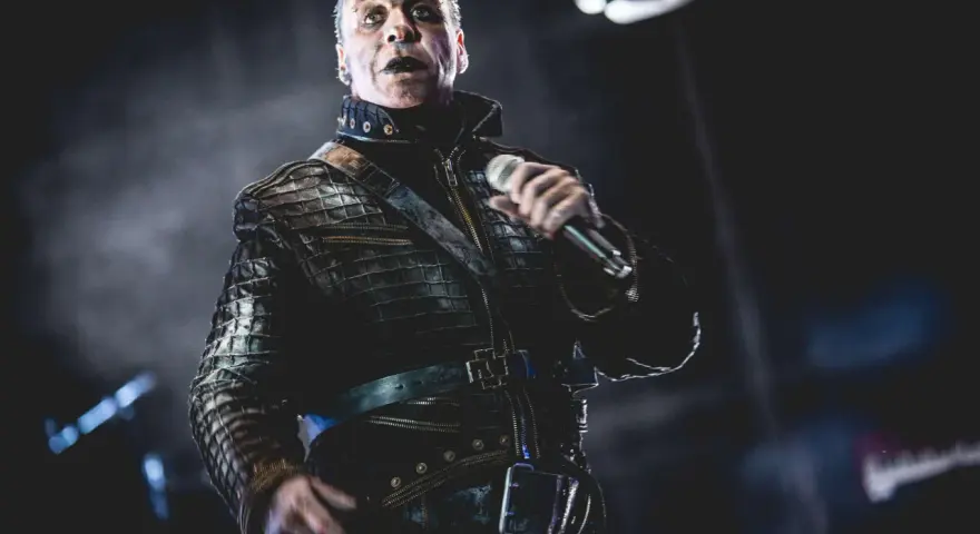 Till Lindemann w skórzanej kurtce, z mikrofonem w dłoni, jakby opowiadał historię swojej żonie.