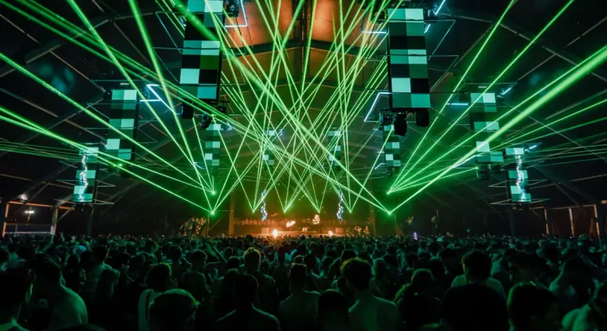 Tłum ludzi na koncercie, zielone lasery tworzą niesamowitą atmosferę. To właśnie jest **rave co to** za przeżycie!