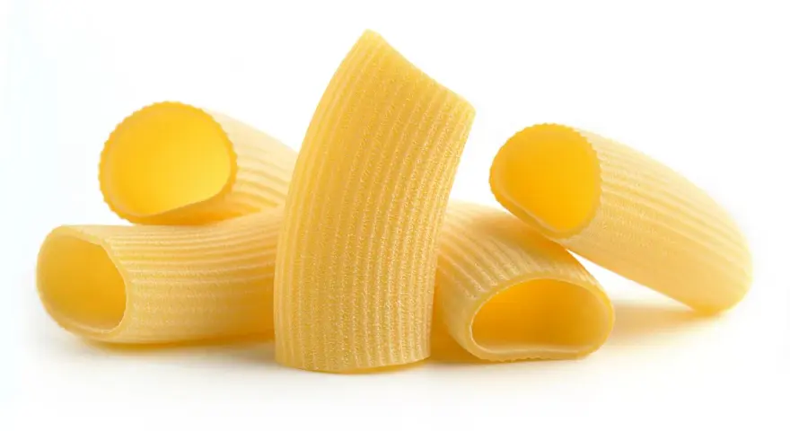 Kilka kawałków makaronu rigatoni, z charakterystycznymi rowkami, gotowych do sosu.