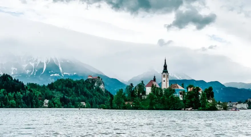 Jezioro Bled ze słynną wyspą i kościołem to obowiązkowy punkt, co warto zobaczyć w Słowenii. W tle góry.