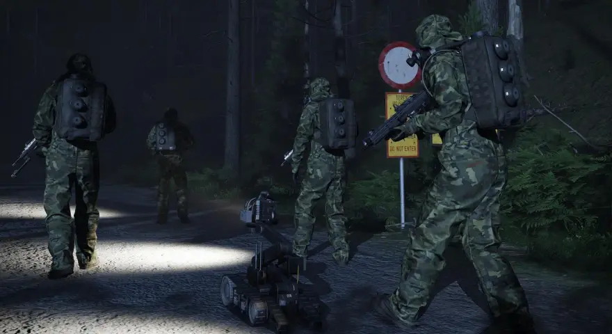 Żołnierze w kamuflażu i robot zwiadowczy na nocnej drodze leśnej.