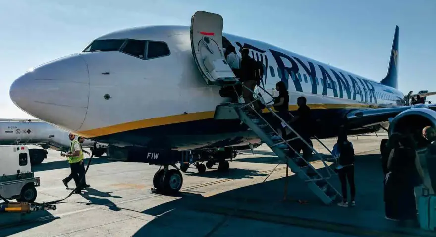 Ryanair samolot, pasażerowie wsiadają. Pamiętaj o zasadach, jak przewozić leki w samolocie Ryanair, by podróż przebiegła sprawnie.