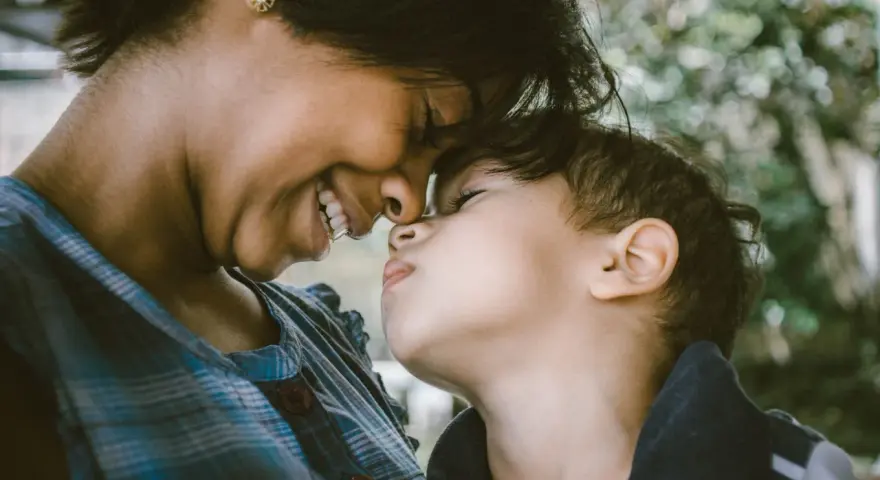 Ein inniges Lächeln verbindet Mutter und Kind. Ihre Nasen berühren sich, ein Moment purer, unendlich liebe zum Kind.