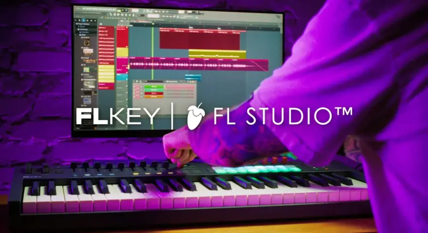 Ręce tworzą muzykę na klawiaturze MIDI, sterując programem FL Studio.