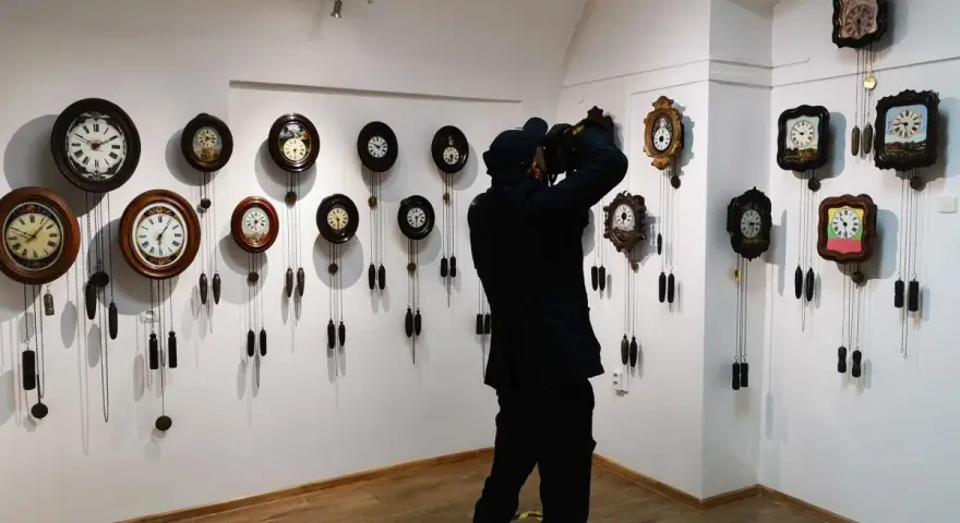 Odwiedzający dokumentuje bogactwo kolekcji największego muzeum zegarów w Polsce, gdzie wiszą dziesiątki zabytkowych czasomierzy.