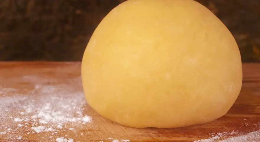 Impasto giallo dorato, pronto per diventare la base perfetta per una deliziosa pasta frolla per pastiera.