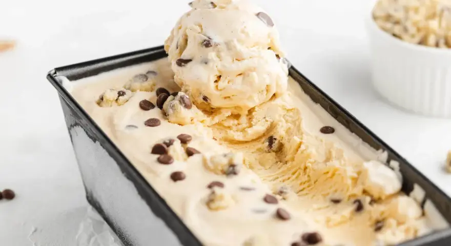 Cremiges Cookie Dough Eis mit Schokoladenstückchen in einer rechteckigen Form.
