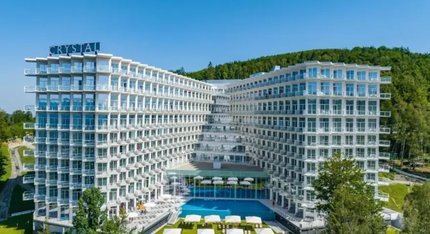 Nowoczesny hotel Crystal w Wiśle, z basenem i tarasami, otoczony zielenią. Idealne miejsce na górski relaks w Wiśle Mountain Spa.
