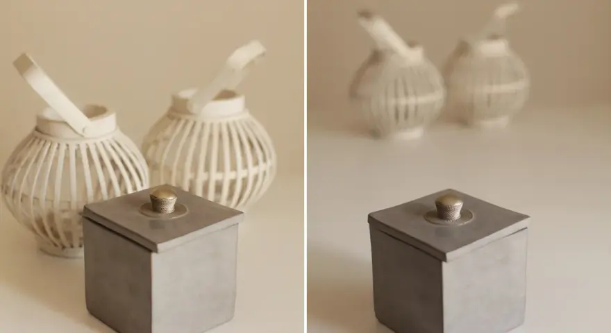 Boîte grise avec couvercle orné d'un bouton argenté, lanternes blanches en arrière plan avec un flou arrière plan artistique.