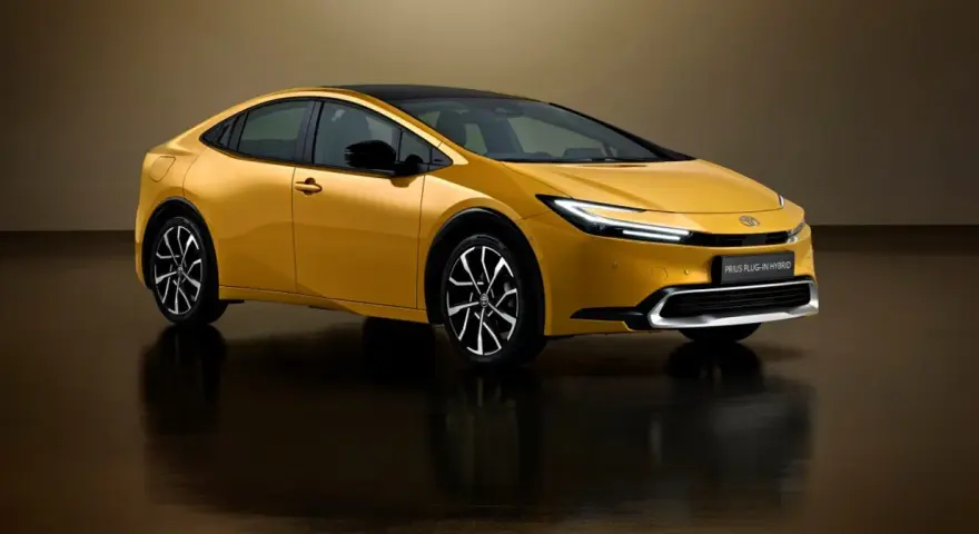 Złoty Toyota Prius Plug-in Hybrid z czarnym dachem, nowoczesnymi światłami i stylowymi felgami.
