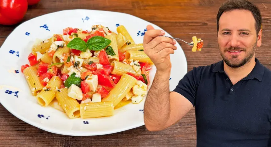 Un uomo sorride mentre assaggia una forchettata di pasta alla checca, un piatto fresco con pomodori, mozzarella e basilico.