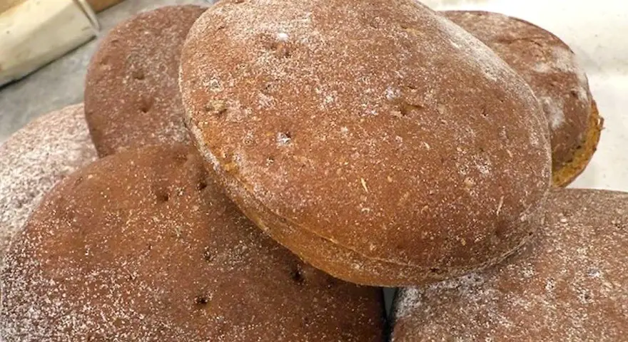 En hög med nybakade rågkakor, perfekta för ett enkelt rågkaka recept. Strödda med lite mjöl.