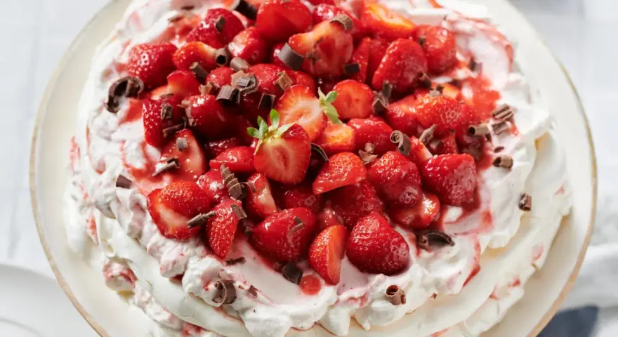 Ein köstliches Pavlova Rezept mit frischen Erdbeeren und Schokostreuseln.