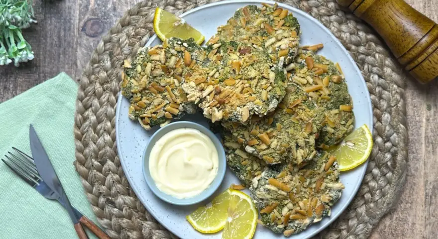 Spinacine fatte in casa croccanti, servite con maionese e spicchi di limone. Un piatto gustoso e salutare.