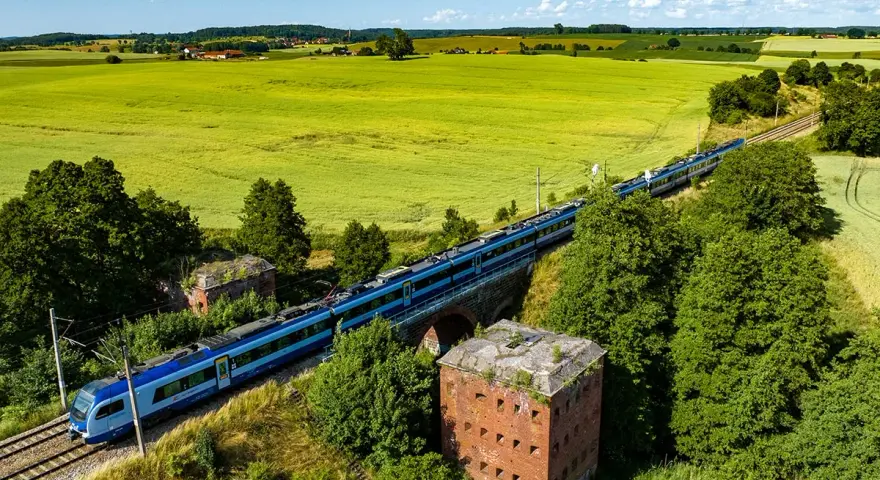 Pociąg mknie przez zielone pola, mijając stare forty. Idealny sposób, by dowiedzieć się, gdzie na Mazury pociągiem.