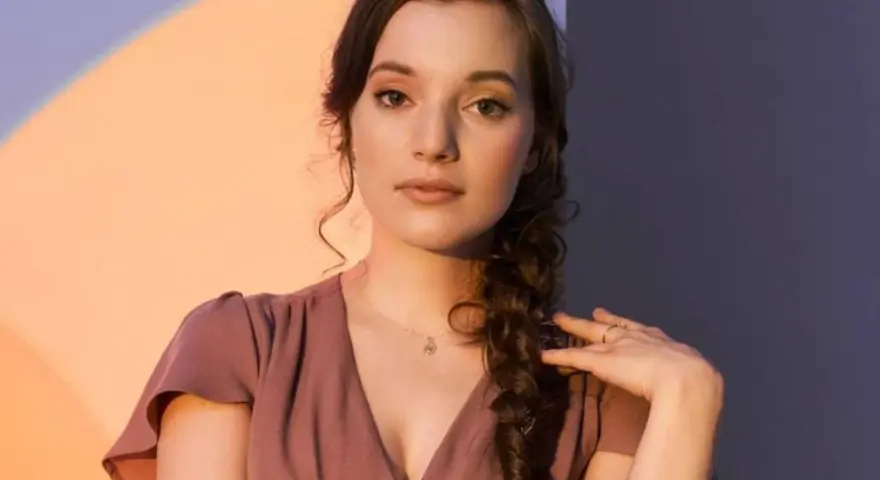 Sanah w The Voice of Poland przesłuchania. Młoda artystka w różowej sukience z warkoczem.