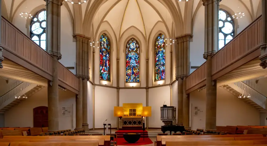 Festlicher evangelischer Gottesdienst am Heiligabend in einer Kirche mit Buntglasfenstern und Holzbänken.
