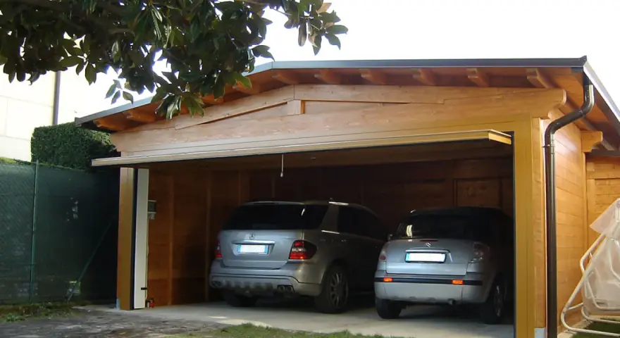 Doppio garage in legno con due auto. La struttura rispetta la normativa garage privati, offrendo un riparo sicuro e funzionale.