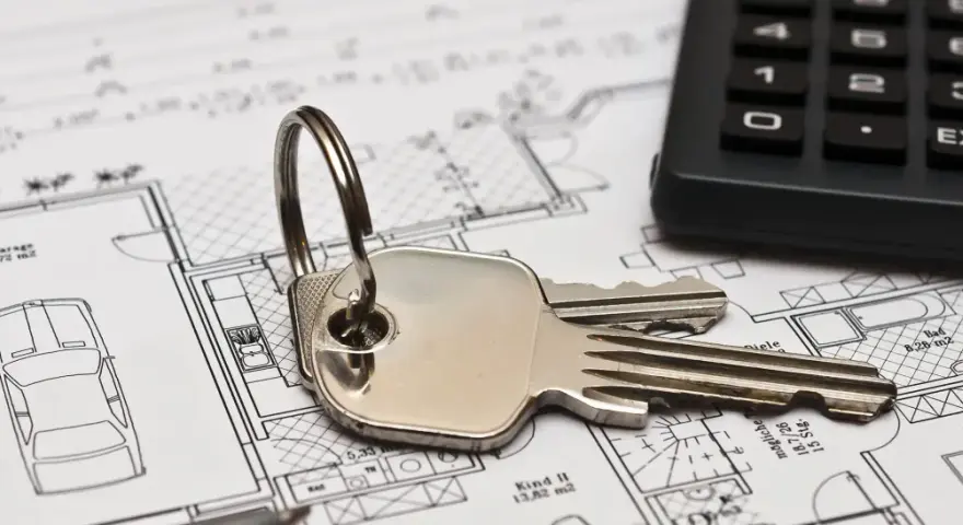Schlüssel und Taschenrechner liegen auf Bauplänen. Ein Haus mit Garage und Zimmern ist zu sehen. Ideal für Mietrecht Oberhausen.