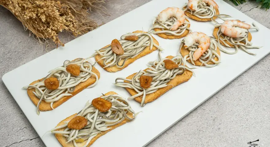 Deliciosas tostas con gulas y gambas, perfectas para tus recetas con gulas para cenar. Un bocado exquisito.