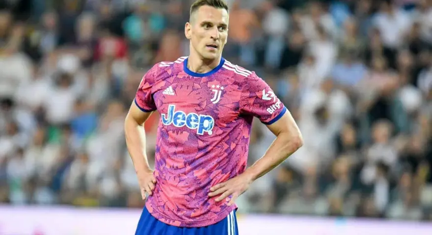 Piłkarz Arkadiusz Milik w różowej koszulce Juventusu z logo Jeep.