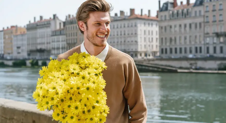 Hombre sonriente con un gran ramo de flores amarillas, quizás buscando el significado de flores para hombres.