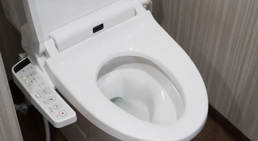 Panneau de commande d'une toilette japonaise. Il montre les options de nettoyage et de séchage, illustrant le fonctionnement de cet appareil moderne.