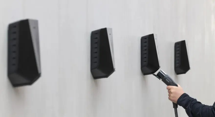 En hand håller en laddkabel mot en Easee laddbox. Ett potentiellt Easee laddbox problem kan vara att kabeln inte kopplas in korrekt.