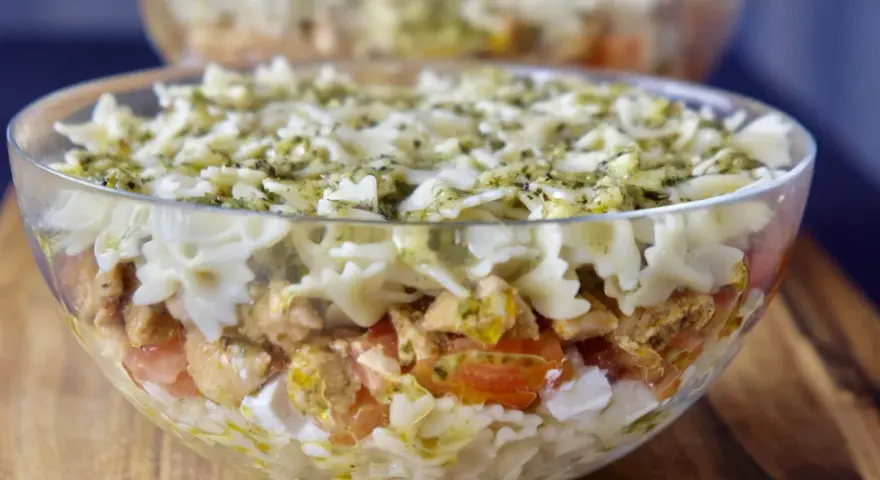 Pyszna sałatka z kurczakiem i makaronem farfalle, polana sosem pesto. Idealna na letnie dni.