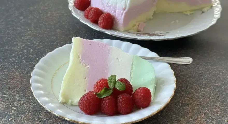 Puszysta pianka z galaretki i jogurtu w kolorach pastelowych, udekorowana malinami.