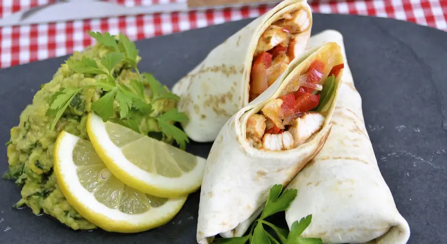 Fajitas de pollo jugosas con guacamole, limón y perejil.