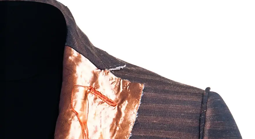 Dettaglio di una giacca destrutturata Armani con fodera color rame e cuciture a vista.