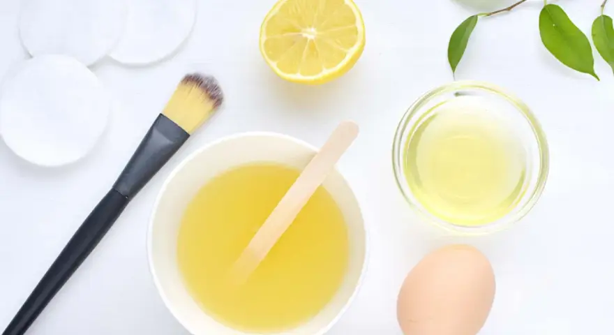 Ingredientes para una mascarilla casera para el pelo: limón, huevo, aceite y aplicador.