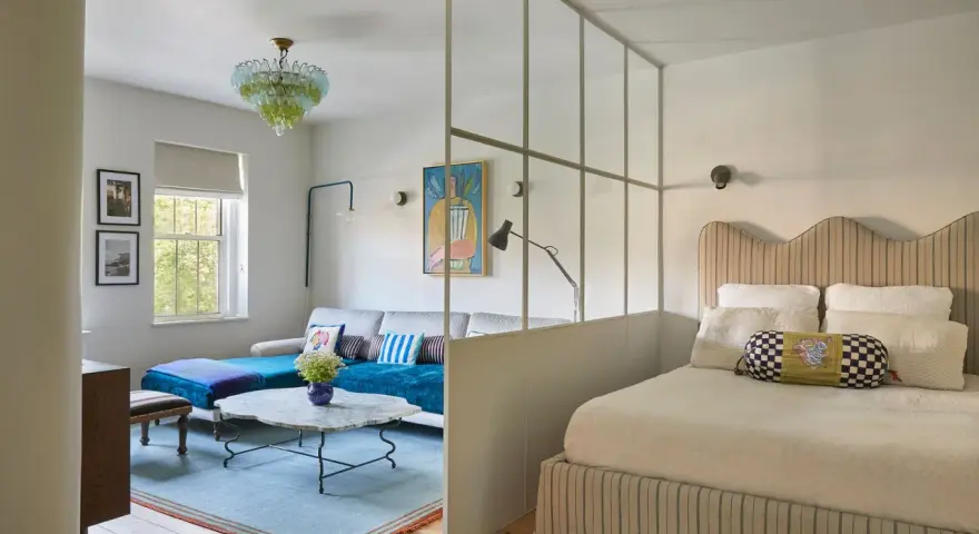 Soluzione creativa per come dividere una camera in due con una sola finestra: zona giorno e zona notte separate da un pannello vetrato.