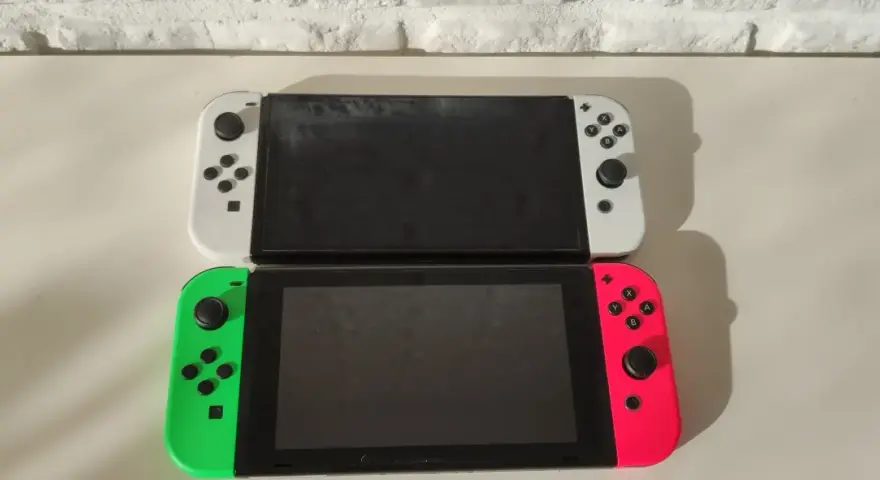 Dwa konsole Nintendo Switch OLED, biała i neonowo-różowa z zielonym Joy-Conem, gotowe na premierę.