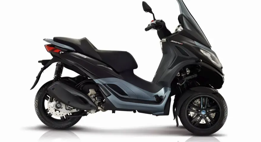 Trójkołowy skuter Piaggio MP3 300 HPE w kolorze grafitowym, z detalami podkreślającymi jego sportowy charakter. Idealny do miasta, z uwzględnieniem piaggio mp3 300 dane techniczne.