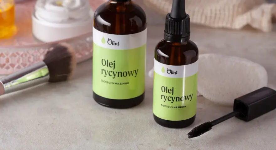 Dwie buteleczki z etykietą "Olej rycynowy" obok pędzla do makijażu i tuszu do rzęs. Idealny do pielęgnacji rzęs.