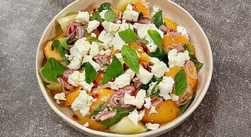 En uppfriskande melon och fetaostsallad med basilika och rödlök. Perfekt sommarbuffé.