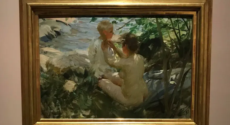 Anders Zorn fångar två barn vid en bäck. En flicka klär på en pojke i solljus.