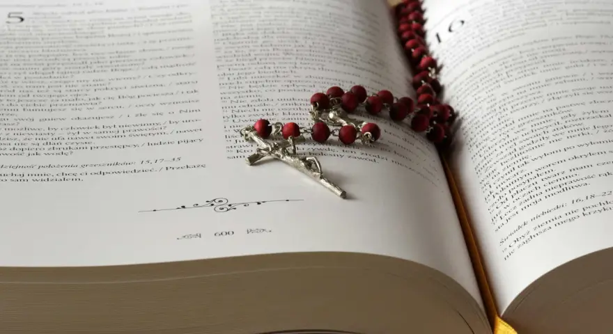 Modlitwa za zmarłą żonę. Różaniec na otwartej księdze, symbol wiary i pamięci.