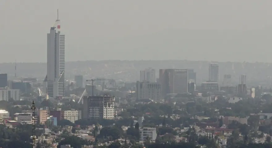 Vista panorámica de Guadalajara con edificios altos y una neblina que afecta la calidad del aire.