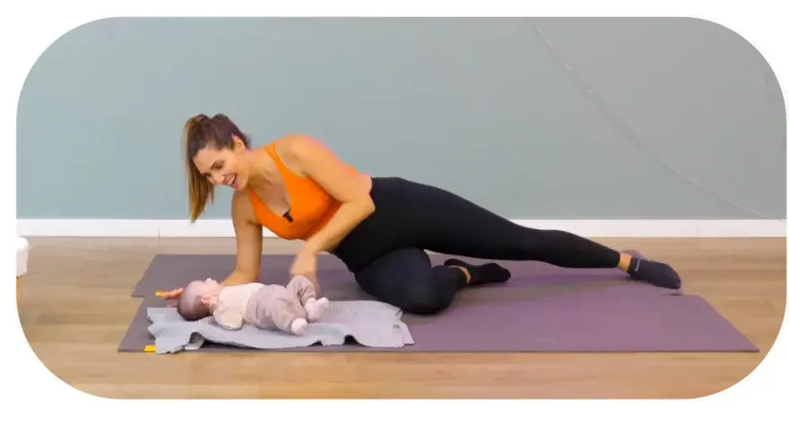 Une femme fait du sport après accouchement, en position de planche latérale, avec son bébé à ses côtés.