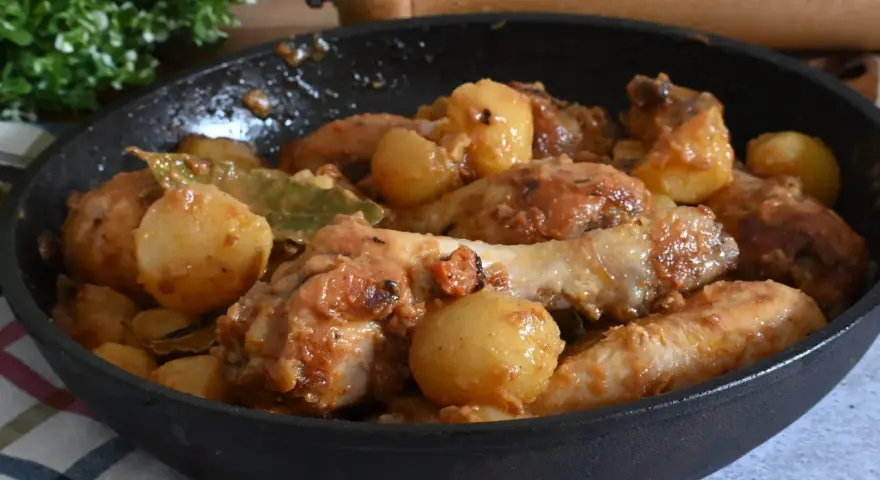 Un saporito pollo in umido con patate e alloro, cotto in padella.