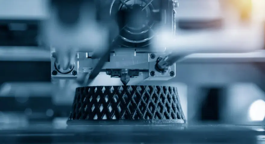 Close-up of an advanced 3D printing machine creating a complex, lattice-like object layer by layer.